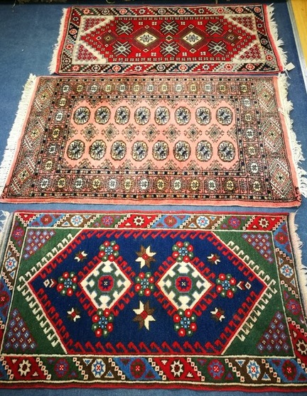 A Bokhara style mat and two others 116 x 66cm, 130 x 81cm and 125 x 65cm